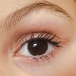 Donkerbruin oog dat recht in de camera kijkt, symbool voor vertrouwen en aandacht.