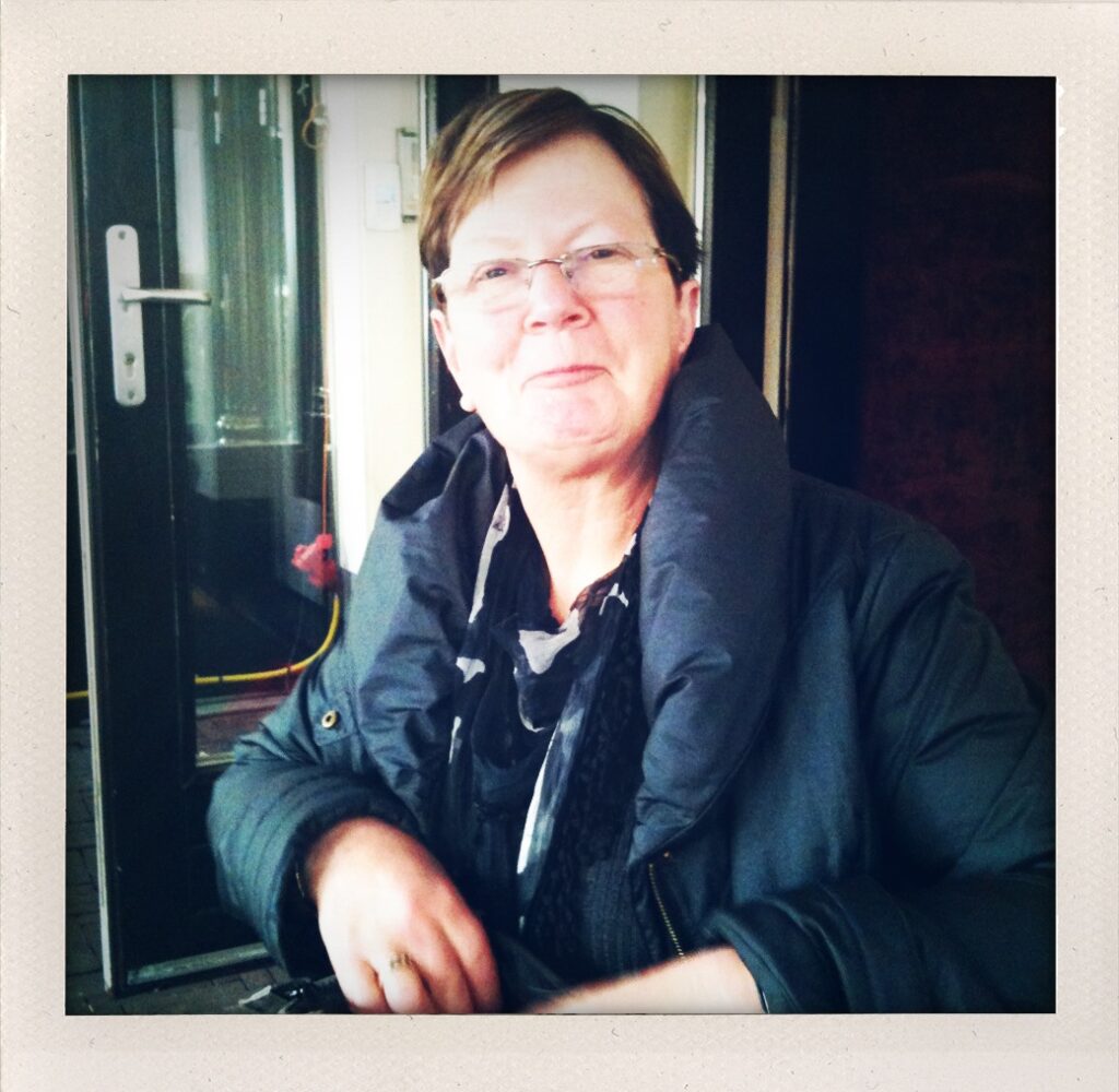 Foto van mijn moeder, lachend en ontspannen. Een ode aan haar liefdevolle energie en zorg, die een belangrijke rol speelt in mijn familieopstelling-verhaal.