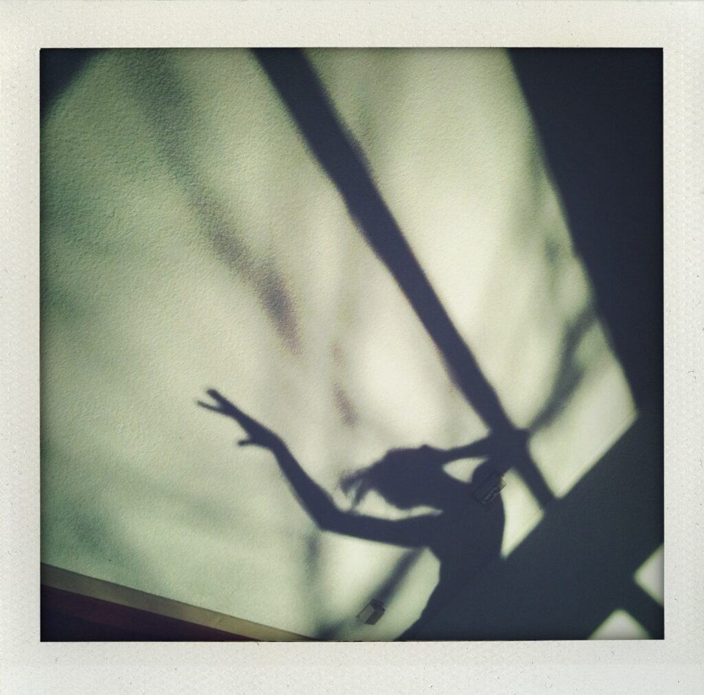 Schaduw van een dansende vrouw op de muur, symbool voor verandering, vrijheid en persoonlijke groei. Een beeld uit mijn eigen zoektocht naar balans