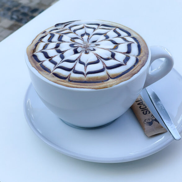 kop koffie met latte art op een tafel
